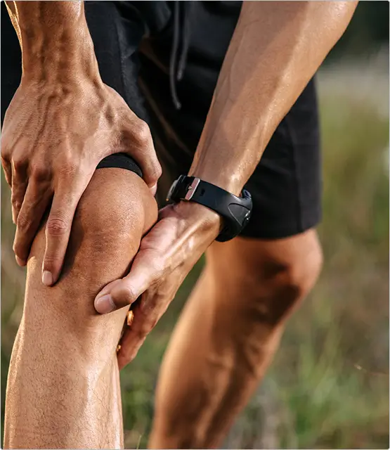 Person holding their knee in pain, illustrating chronic joint pain conditions such as knee osteoarthritis, tennis elbow, and frozen shoulder treated at California Joint Pain Institute in Irvine, CA.